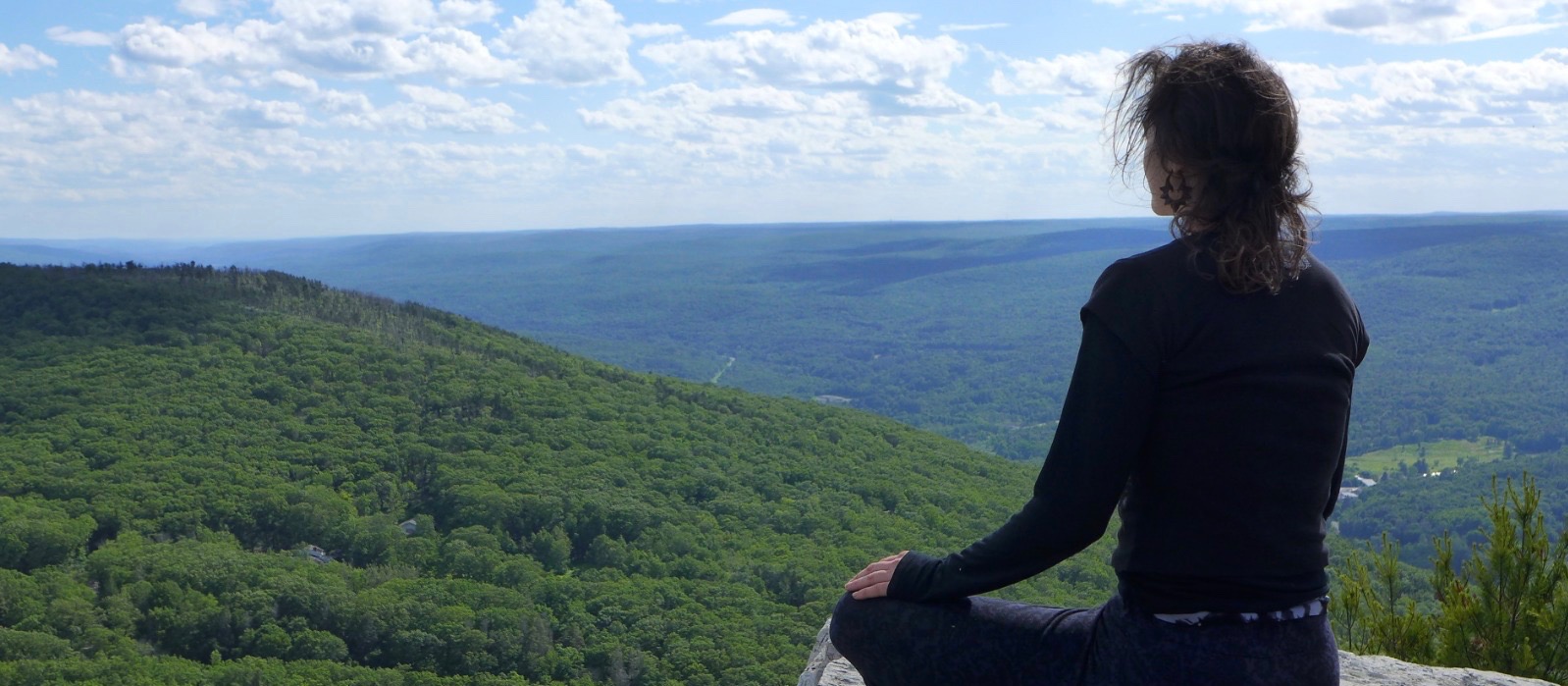 Girl meditating on a mountaintop