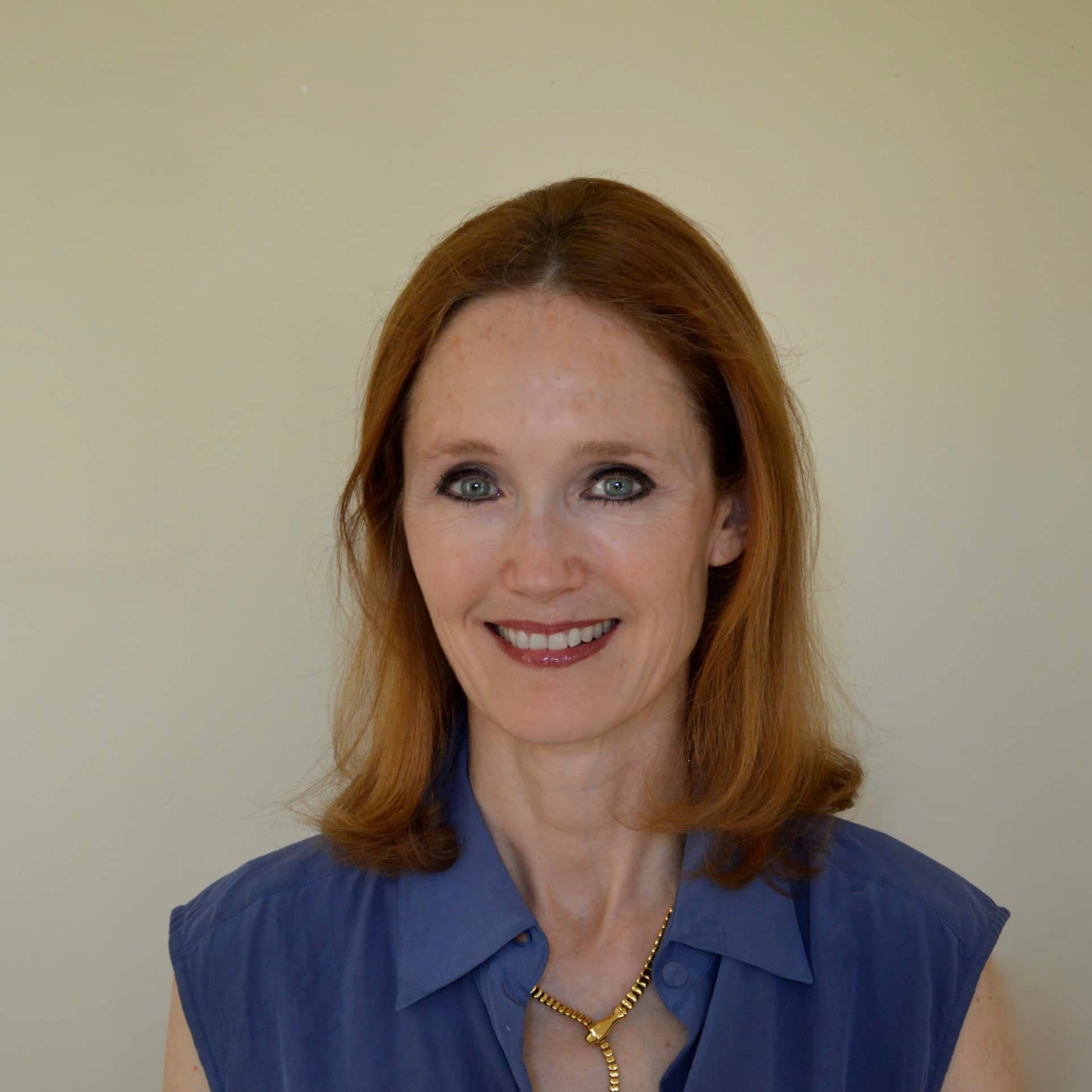 Woman in a blue shirt with a gold necklace